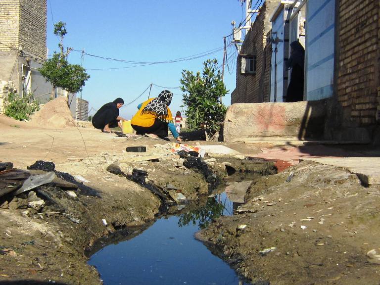 در اینجا گنداب سیاهی به اسم فاضلاب در همه جا جاری است. معنای زن و کودک و اساساً انسان دراینجا رنگ می بازد. مختصری از پولهایی که در قمار هسته ای از کف رفت اگر به این خراب آباد راه می یافت، اکنون این زنان با لجن بد بوی جلوی بیغوله هایشان ور نمی رفتند تا راهی برای خروج آن بجویند.محمد نوریزاد در اینجا گنداب سیاهی به اسم فاضلاب در همه جا جاری است. معنای زن و کودک و اساساً انسان دراینجا رنگ می بازد. مختصری از پولهایی که در قمار هسته ای از کف رفت اگر به این خراب آباد راه می یافت، اکنون این زنان با لجن بد بوی جلوی بیغوله هایشان ور نمی رفتند تا راهی برای خروج آن بجویند.محمد نوریزاد