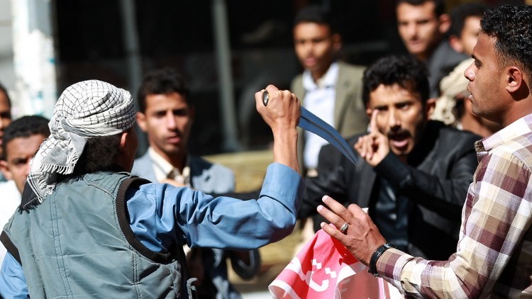 یکی از شورشیان گروه الحوثی در حال تهدید معترضان یمنی است یکی از شورشیان گروه الحوثی در حال تهدید معترضان یمنی است